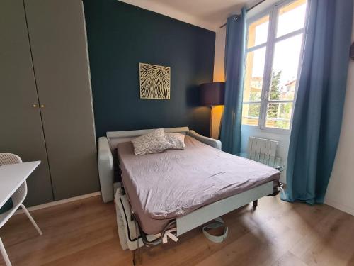 sypialnia z łóżkiem w pokoju z niebieskimi ścianami w obiekcie Studio 700 m du Palais et Croisette - Le St Jean w Cannes
