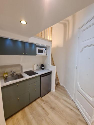 une cuisine avec un évier et un micro-ondes dans l'établissement Studio 700 m du Palais et Croisette - Le St Jean, à Cannes