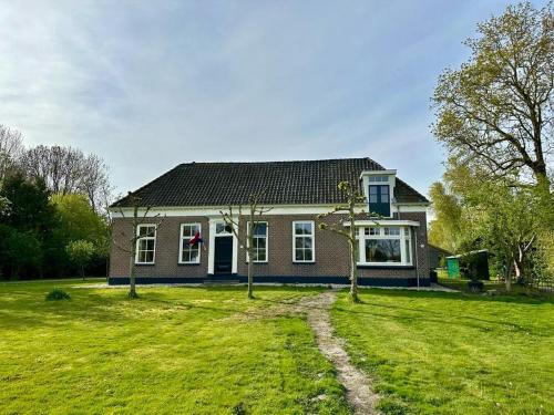 una casa con un cortile verde davanti di Kleine Huisje a Ruinerwold
