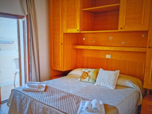 a bedroom with a bed with a wooden wall at LE CAMERE SUL PORTO in Palau