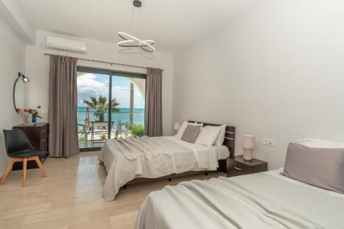 a bedroom with two beds and a view of the ocean at Villa Milano in Laganas