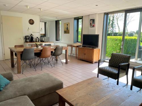 ein Wohnzimmer mit einem Sofa und einem Tisch in der Unterkunft Vakantieoord "de Peppelhoeve" in Koudekerke