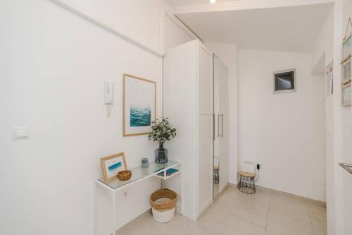Dieses weiße Zimmer verfügt über einen Flur mit einem Spiegel. in der Unterkunft Sea view and More apartment in Novalja