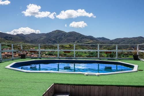 una gran piscina en un campo con montañas en el fondo en B&B L'Aurora en Ceraso