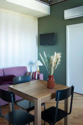 a dining room table with chairs and a vase of flowers at Coltivare AgriRelais in La Morra