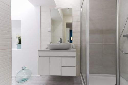 a white bathroom with a sink and a shower at Benfica Apartments I by Homing in Lisbon