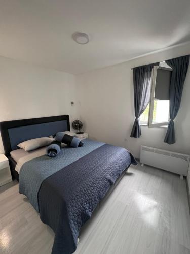 - une chambre avec un grand lit et une couverture bleue dans l'établissement Amani, à Kovačevo Polje