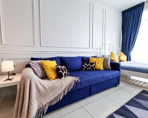 een blauwe bank met kleurrijke kussens in de woonkamer bij Victoria Beacon Executive Suites by Bin Dao Wu Homestay Penang in George Town