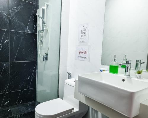 een badkamer met een wastafel, een douche en een toilet bij Victoria Beacon Executive Suites by Bin Dao Wu Homestay Penang in George Town
