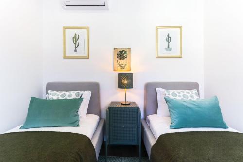 2 letti posti uno accanto all'altro in una stanza di Benfica Apartments III by Homing a Lisbona