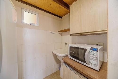 una piccola cucina con forno a microonde e lavandino di Casa p/ 4, wifi, ar, gara a Joinville