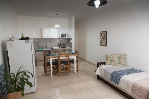 a bedroom with a bed and a kitchen with a table at Los Palos Ribera Norte in Playa Unión