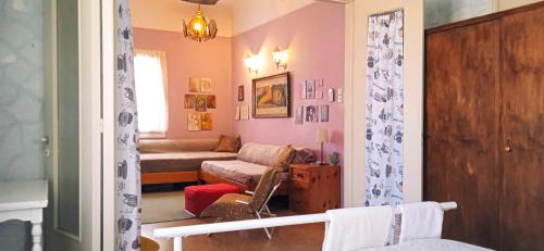een woonkamer met een bank en een stoel bij TWO-BEDROOMS in GREEK VINTAGE HOME with shared Bathroom in Korinthos