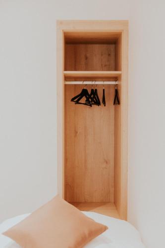 a closet with a wooden door with hangers at Luxe Vakantiewoning De Veldhoek in Wingene