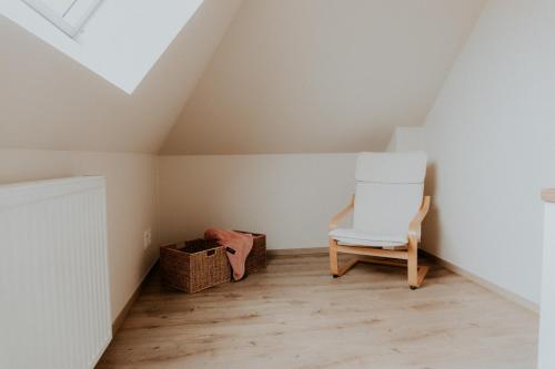a room with a white chair in a attic at Luxe Vakantiewoning De Veldhoek in Wingene