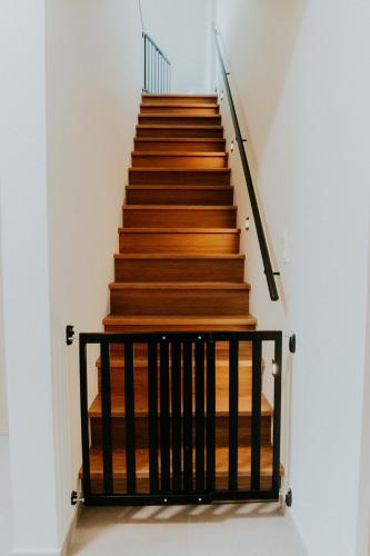 a staircase with wood and black railings in a room at Luxe Vakantiewoning De Veldhoek in Wingene