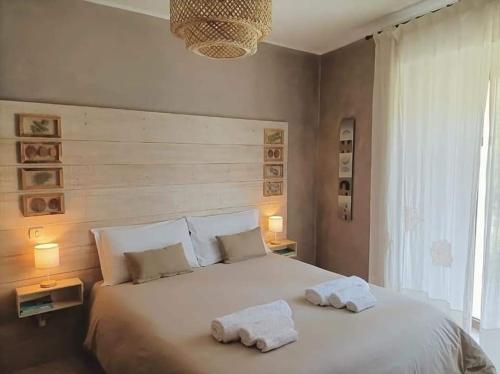 Bed & Bike Frasassi في Falcioni: غرفة نوم بسرير ابيض كبير عليها مناشف