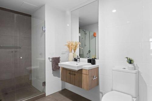 a bathroom with a toilet and a sink and a shower at Prestige 2bd Apartment Gym/Pool in Adelaide