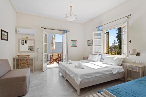 a bedroom with two beds and a couch at Villa Kalomira in Spetses