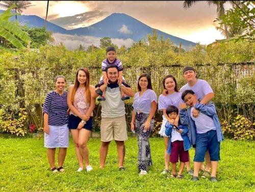 a family posing for a picture with a mountain in the background at Lavs Valley in Dapdap