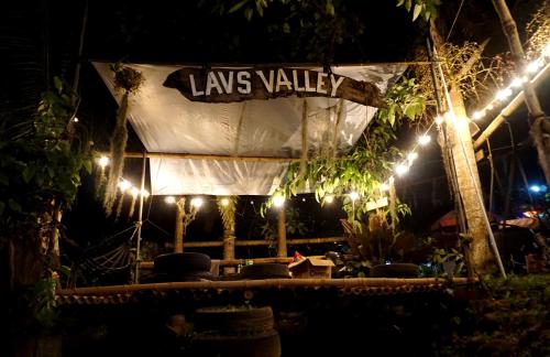 a sign for a loungery at night with lights at Lavs Valley in Dapdap
