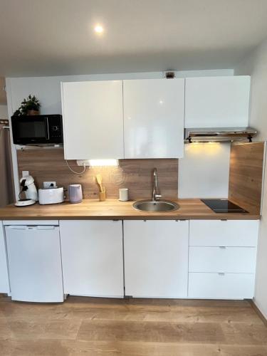 a kitchen with white cabinets and a sink at Vivez l'Horizon sur la mer - Vue mer - plage - Port de plaisance in Le Havre