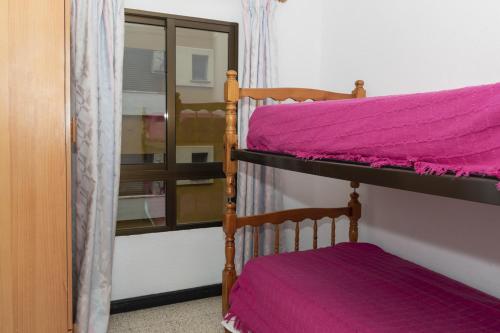 1 dormitorio con 2 literas con sábanas moradas en Estirpe, 2º-4 en Cullera