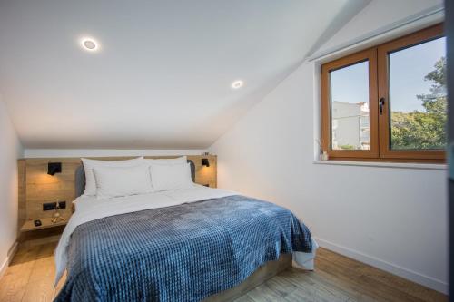 biała sypialnia z łóżkiem i oknem w obiekcie Oleander Urban Suites, high-speed internet, beach at 250, PET friendly w Trogirze