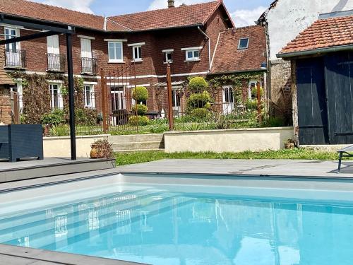 a large swimming pool in front of a house at Le Paddock - Chambres et table d'hôtes in Le Déluge
