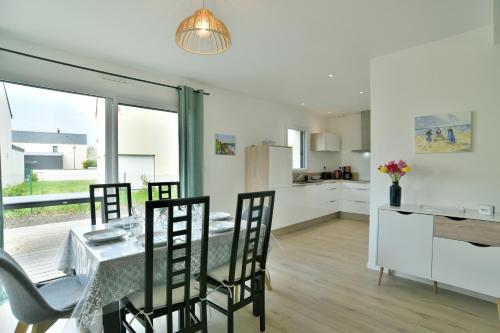 une cuisine et une salle à manger avec une table et des chaises dans l'établissement Les Belles Noës, à Saint-Briac-sur-Mer
