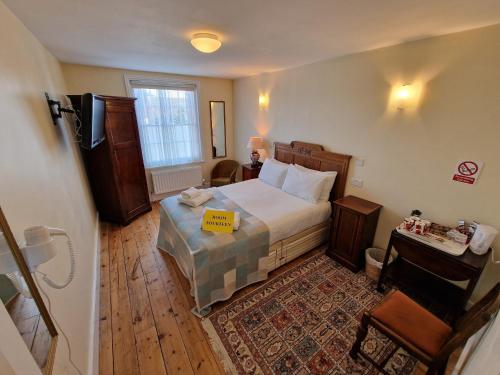 a bedroom with a bed with a yellow sign on it at Canterbury Black Horse Inn in Canterbury