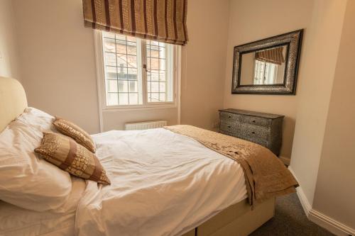 1 dormitorio con cama blanca y espejo en Bridge Street Views, en Chester