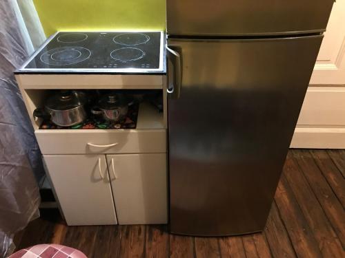 a black refrigerator with a stove in a kitchen at Cozy condo for up to 3 travellers, with kitchen and bath in Rīga