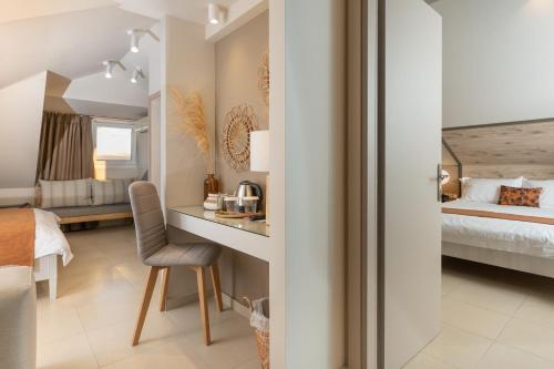 a bedroom with a bed and a desk with a chair at ELLE Rooms & Suites in Paralia Katerinis