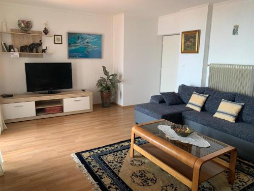 sala de estar con sofá azul y TV en Apartments Diana en Opatija