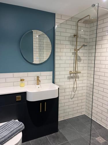 a bathroom with a sink and a shower at The Piggery in Chichester
