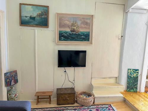 ein Wohnzimmer mit einem TV an der Wand in der Unterkunft Brač, Supetar, ART HOUSE, Dreamy Dalmatian vacation home, 80m from sea in Supetar