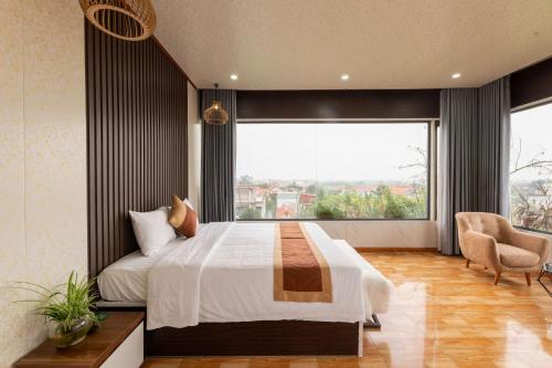 a bedroom with a large bed and a large window at TAM COC SUNSHINE HOTEL in Ninh Binh