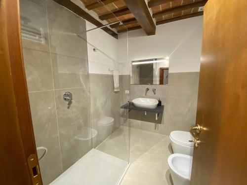 a bathroom with a shower and a toilet and a sink at Civico in Gubbio