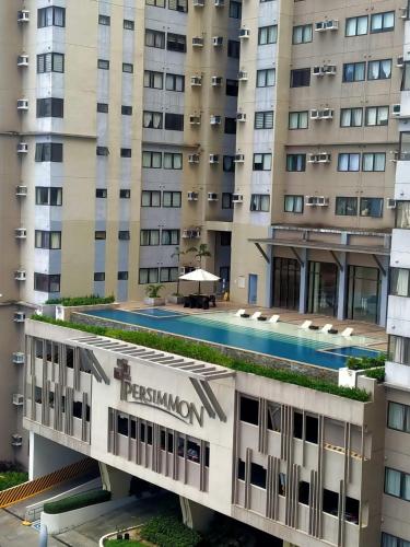 een hotel met een zwembad voor een gebouw bij Persimmon Condominium Cebu City in Cebu City