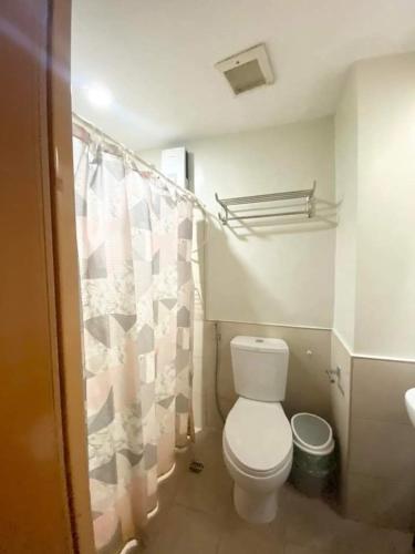 een badkamer met een toilet en een douchegordijn bij Persimmon Condominium Cebu City in Cebu City