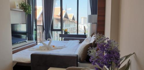 1 dormitorio con cama y ventana grande en The Astra Chiang Mai family room, en Chiang Mai