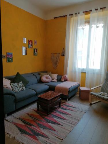 ein Wohnzimmer mit einem blauen Sofa und einem Teppich in der Unterkunft La volpe gialla in Savona