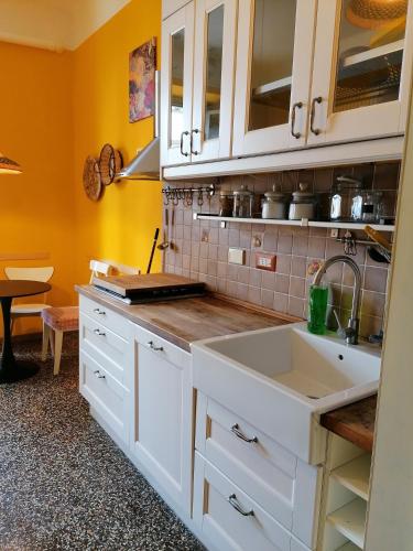 eine Küche mit weißen Schränken und einem Waschbecken in der Unterkunft La volpe gialla in Savona