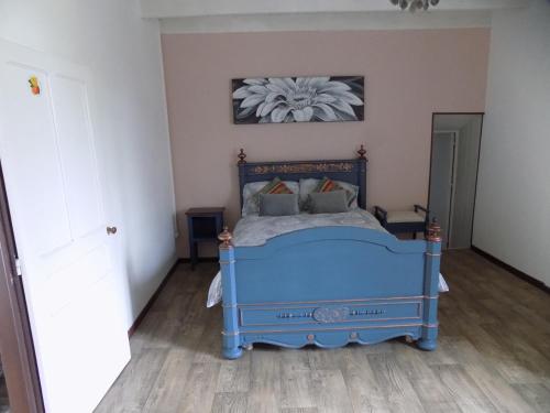 - une chambre avec un lit bleu dans l'établissement La maisonnette, à Les Adjots