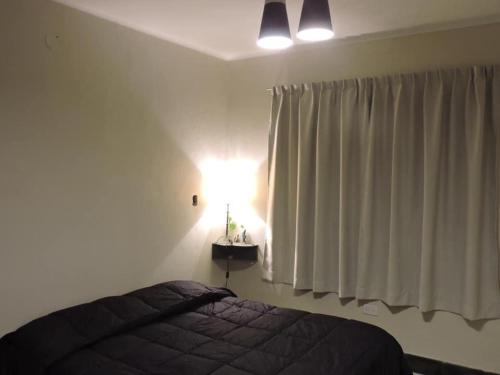 1 dormitorio con cama y ventana con luz en Alojamiento la salteñita en Salta