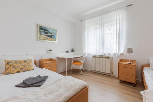 a white bedroom with a bed and a desk at Lisinski apartment with private parking in Zagreb