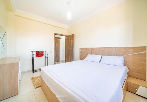 1 dormitorio con 1 cama blanca grande y TV en Appartement 2 chambre 5min Aéroport en Marrakech