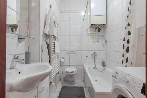 a white bathroom with a sink and a toilet at Lisinski apartment with private parking in Zagreb