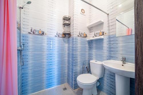 La salle de bains est pourvue de carrelage bleu, de toilettes et d'un lavabo. dans l'établissement Appartement 2 chambre 5min Aéroport, à Marrakech
